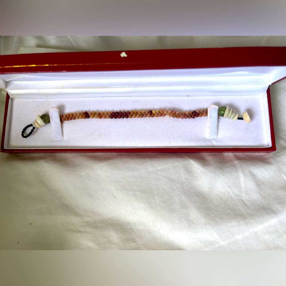 NIIHAU bracelet. Beautiful reds cream with a shell buckle.